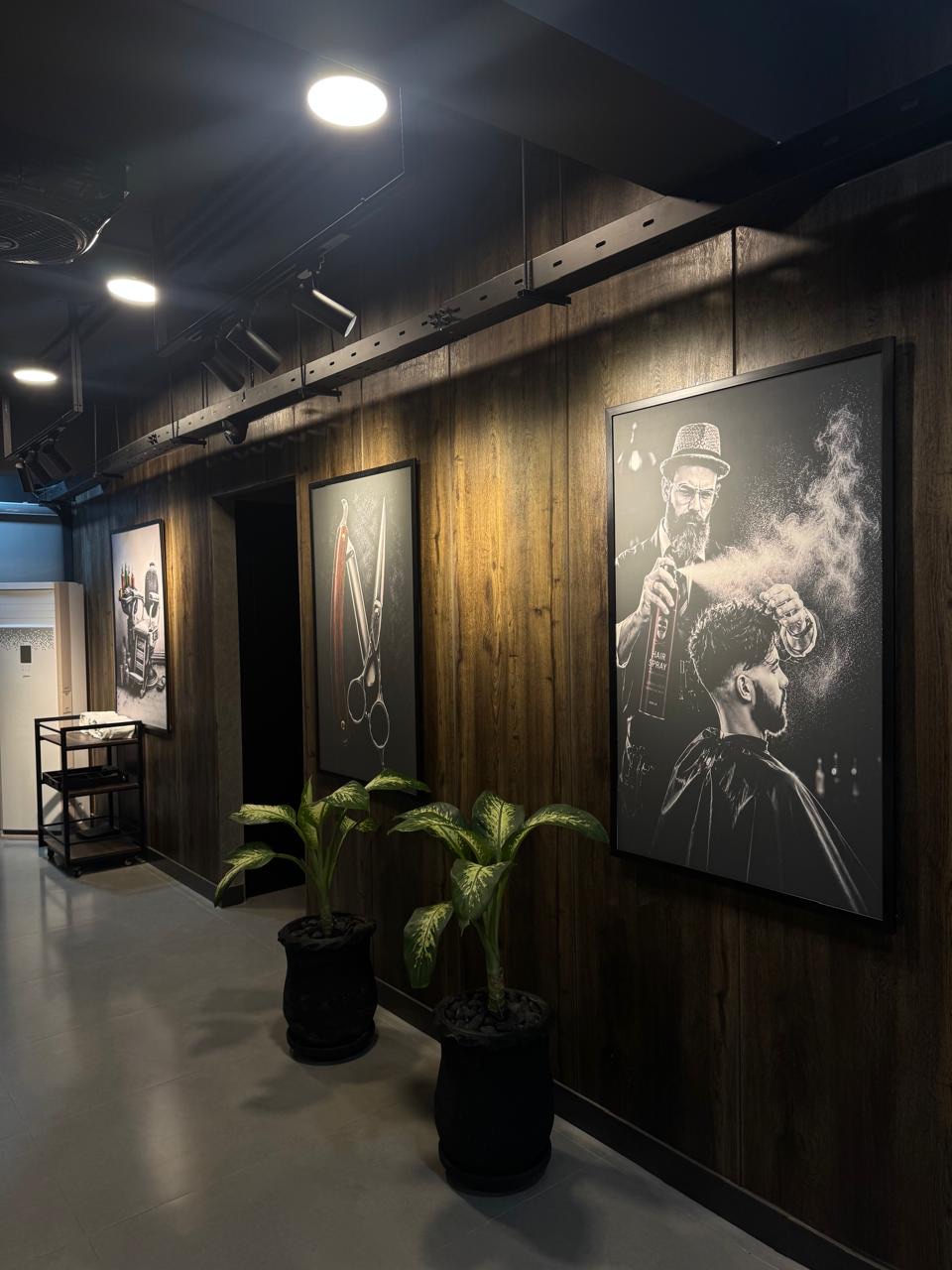 Wood-panelled corridor with framed barber artwork at The Man Redefined
