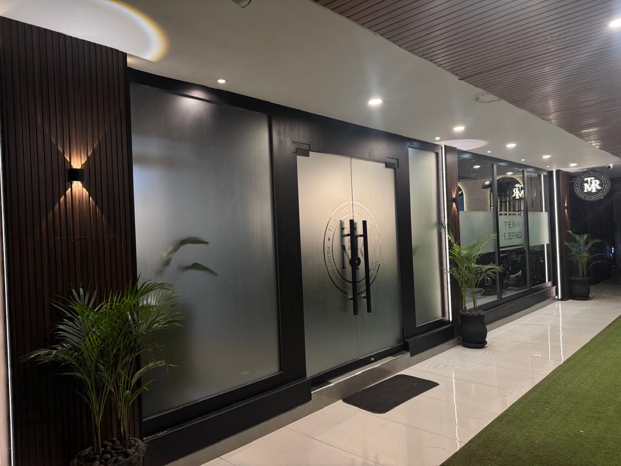 Entrance of The Man Redefined salon with the TMR logo on frosted glass doors, City Plaza, F-10 Markaz, Islamabad