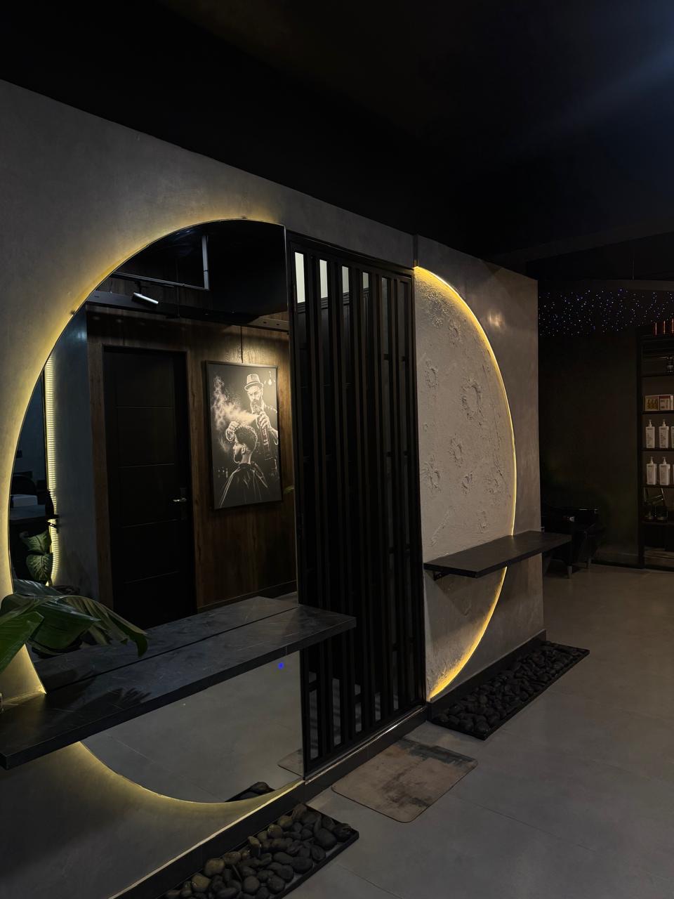 Circular backlit mirror and sculpted moon wall in the corridor of The Man Redefined