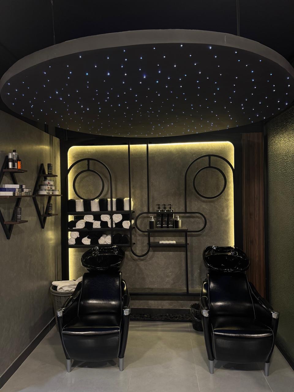 Hair wash station with two black basins and a star-lit ceiling at The Man Redefined